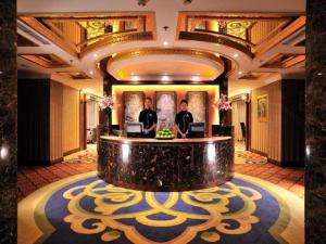 a lobby with two men standing at a reception desk at Hohhot Inner Mongolia Hotel in Hohhot +283 photos