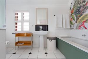 a bathroom with a tub and a sink and a bath tub at Winelands Golf Lodges 9 in Stellenbosch