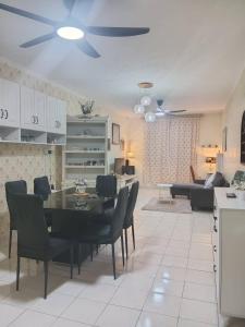 a dining room and living room with a table and chairs at Putatan Platinium 2 Bedroom - Farah Biz Homestay in Putatan
