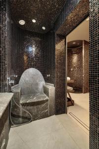 斯维诺乌伊希切Hilton Swinoujscie Resort And Spa的配有椅子和黑色瓷砖的浴室