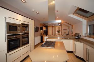 a kitchen with white cabinets and a stove top oven at Inverlea Guest House in Ayr