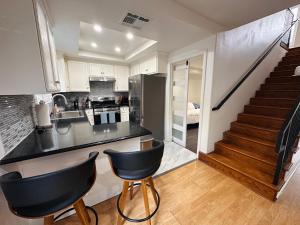 a kitchen with a black counter top and a staircase at Echo House in Los Angeles