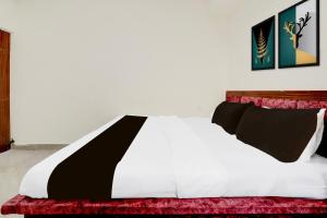 グワーリヤルにあるHotel O Unnati Innのベッド(白黒のシーツ、枕付)