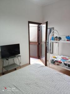 a bedroom with a bed and a flat screen tv at Le Onde di Rossella in Torre Lapillo