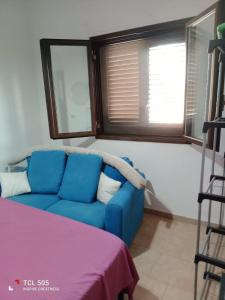a blue couch in a room with two windows at Le Onde di Rossella in Torre Lapillo