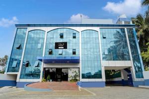 ティルプルにあるCollection O Central Railway Station Tiruppurの時計付きの大きなガラス張り