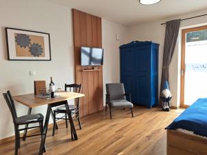 a bedroom with a table and chairs and a blue cabinet at Apartments Gorski raj in Kranjska Gora