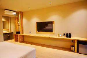 a hotel room with a bed and a flat screen tv at Mayfair Garden Resort in Panglao +54 photos