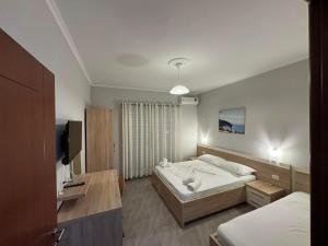 德尔米Augustus Hotel的卧室里有一张床和一台电视机
