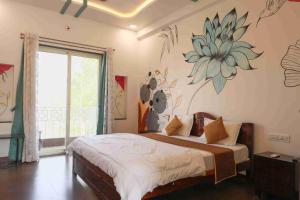 a bedroom with a bed with a flower on the wall at The Dhar Villa in Thūr