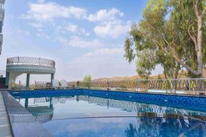 a swimming pool with a gazebo and trees at The Dhar Villa in Thūr