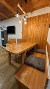 a dining room with a wooden table and a bench at Apartmaji Winter Garden Kranjska Gora in Kranjska Gora