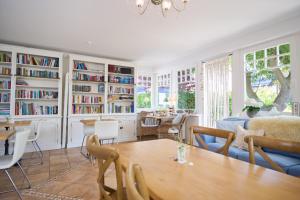 a living room with a table and bookshelves at Landhaus Esperort in Ahrenshoop