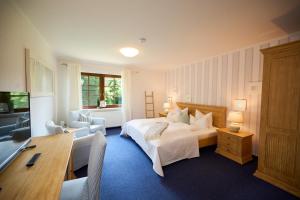 a bedroom with a bed and a table and chairs at Landhaus Esperort in Ahrenshoop