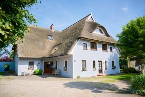an old white house with a thatched roof at Landhaus Esperort in Ahrenshoop