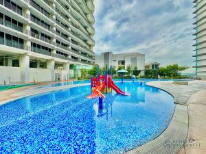 une piscine avec un toboggan au milieu d'un bâtiment dans l'établissement Encorp Marina Residence Puteri Harbour By Stayrene, à Iskandar Puteri