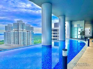 une piscine d'hôtel avec vue sur la ville dans l'établissement Encorp Marina Residence Puteri Harbour By Stayrene, à Iskandar Puteri