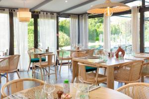 a restaurant with tables and chairs and windows at ibis Salon de Provence in Salon-de-Provence