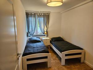 two beds in a small room with a window at Ferienwohnung Freckenhorst in Warendorf