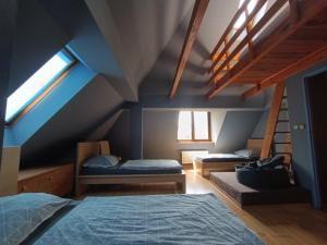 a attic room with two beds and a staircase at Chata Opata in Lubiąż