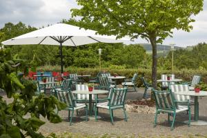a group of tables and chairs under an umbrella at Sunday Hotel Willingen in Willingen