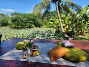 a table with two pillows and a plate of fruit at บ้านสวนปรีดา-Preda Garden Home in Sam Phran