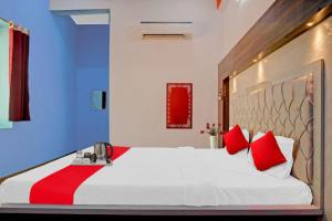um quarto com uma grande cama branca com travesseiros vermelhos em VARANASI HOTEL JSB PALACE -Near Kasi Vishwanath Temple #Fully Air Conditioning #Free Wi-Fi #Parking #Room Service #Best Hotel In Varanasi em Varanasi