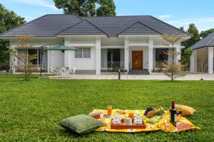 a picnic in the grass in front of a house at Le Jardin - Luxury Private Pool Villa near Kochi, Kerala in Cochin