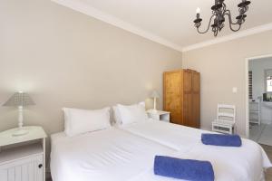 a bedroom with a large white bed with blue towels on it at Winelands Golf Lodges 19 in Stellenbosch