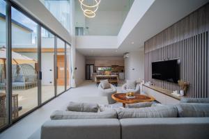 a living room with a couch and a table at 3BR Villa Z by NLA in Ban Pak Lak