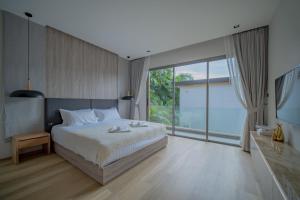 a bedroom with a large bed and a large window at 3BR Villa Z by NLA in Ban Pak Lak +26 photos