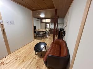 un soggiorno con un divano in pelle e un tavolo di 奈良井駅徒歩10分中山道奈良井宿古民家一棟貸し御宿美里屋 a Shiojiri