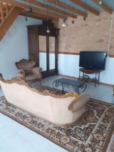 a living room with a couch and a tv at Gites Domaine de Sweendy in Le Bugue