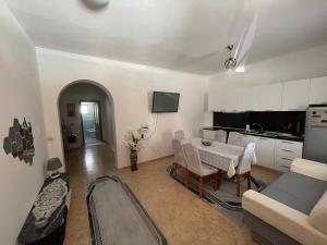 a living room with a table and a kitchen at Anthony&Amar in Berat