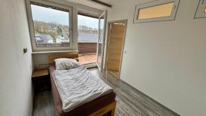 una cama en una habitación con ventana en Pension am Teutoburger Wald, en Georgsmarienhütte