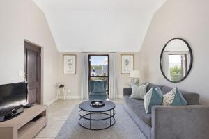a living room with a couch and a tv at Winelands Golf Lodges 21 in Stellenbosch