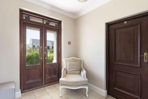 a room with a door and a chair and a window at Winelands Golf Lodges 21 in Stellenbosch +32 photos