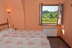 sypialnia z 2 łóżkami i oknem w obiekcie Posada La Roblera w mieście Oreña
