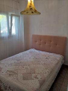 a bedroom with a bed and a chandelier at Sea view house in Sozopoli