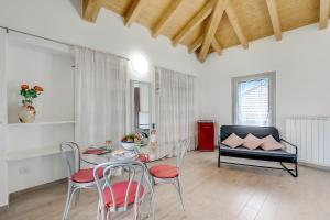 a living room with a table and chairs and a couch at Residenza Quadrifoglio in Casalzuigno