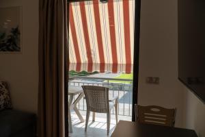 a view of a balcony with a table and chairs through a window at SUNRISE in Agiokampos