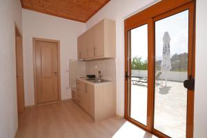 a kitchen with a sink and a large window at Jons Apartment in Gjirokastër