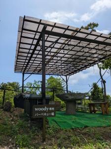 a wooden pergola with a sign under it at niko villa 伊豆高原Woody棟 in Ito