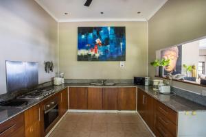 Una cocina con gabinetes de madera y encimera. en Villa Taman Indah, en Lovina