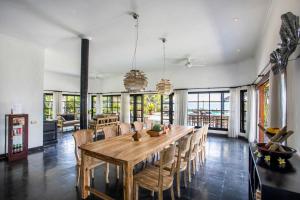 Un comedor con mesa y sillas de madera. en Villa Rumah Rindu, en Lovina
