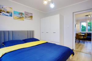 a bedroom with a blue and yellow bed and a table at Karola Miarki, Sun & Snow in Świnoujście +2 photos