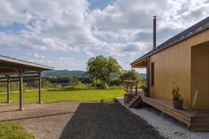 a wooden building with a bench next to a field at Pajtanella in Zebegény