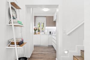 a white kitchen with white cabinets and a staircase at Winelands Golf Lodges 28 in Stellenbosch