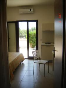 トッレ・ラピッロにあるIl Sole Il Mare Il Ventoのベッドルーム1室(ベッド1台、椅子1脚付)、キッチン