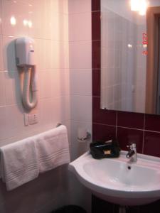 a bathroom with a sink and a phone on the wall at Il Sole Il Mare Il Vento in Torre Lapillo